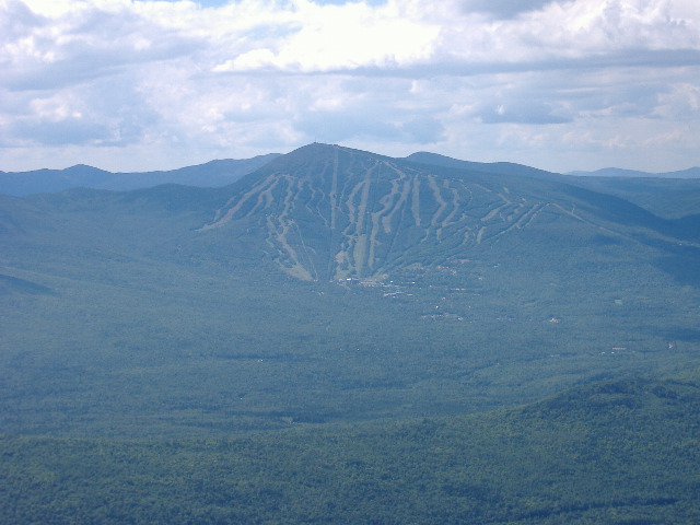 mm 28.3 - One more photo from the summit of Avery Peak, just this time to the south. Now you are looking across the Carrabassett Valley at Sugarloaf Mountain withits world reknowned ski slopes which you get to climb in Maine Section 6. Beyond, the bump on the right is Spaulding Mt. and the Mt. Abraham ridgeline is to the left of Sugarloaf. All to be climbed later in your journey south in section 6.  Courtesy askus3@optonline.net